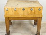 a small wooden table with four drawers on it