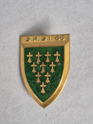 une photo d'un insigne vert et doré orné d'arbres