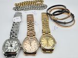several watches and bracelets are sitting on a white surface