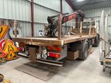 a truck with a crane on the back of it in a warehouse