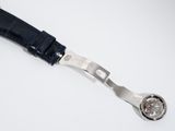 strap of a watch on a white surface with a watch in the middle