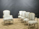 four chairs in a room with a black wall and a wooden floor