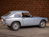 a silver car that is parked in front of a brick wall