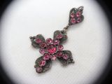 an image of a close up of a cross with pink stones