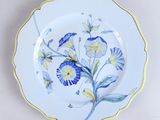 une assiette bleue et jaune décorée de fleurs
