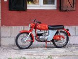 une moto rouge garée devant un immeuble rouge