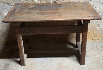 une petite table avec un plateau en bois posée sur un sol en ciment