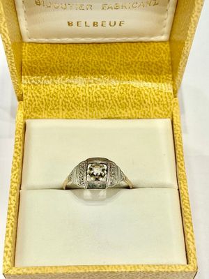 an image of a ring in a box on a white surface