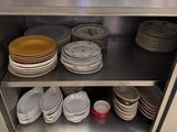 many plates and bowls stacked on a shelf in the kitchen