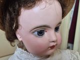 a close up of a doll with a hat on