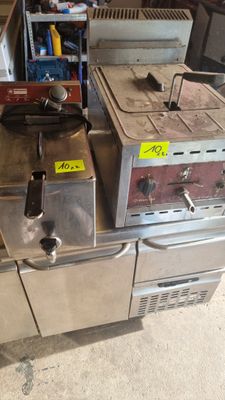 two deep fryers sitting on top of a metal counter