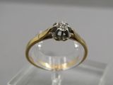 gros plan d'une bague en or surmontée d'un diamant