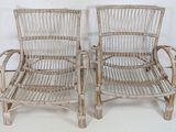pair of white wicker chairs with arms and legs