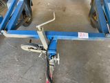 a blue trailer with a wheel on it in a garage