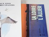 two books sitting on top of a white table next to each other