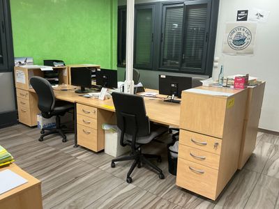 a desk with two computers and two chairs in this office