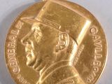 une médaille d'or sur laquelle figure l'image d'un homme portant un chapeau de diplômé