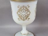 une tasse blanche et dorée ornée d'un motif doré