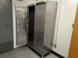 a large stainless steel refrigerator in a public restroom