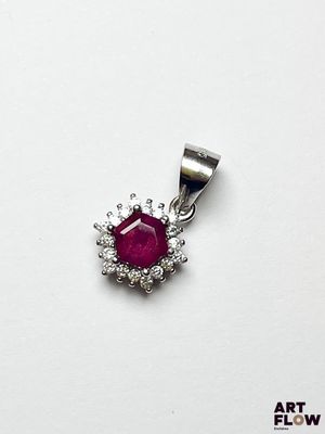 un gros plan d'un pendentif en rubis et diamants sur fond blanc