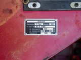 a close up of a metal plate on a red tractor