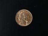 a close up of a gold coin on a black surface