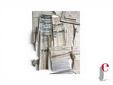 a pile of old newspapers on a white surface