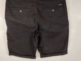 men ' s black shorts on a hanger against a white wall