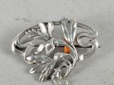 sterling silver brooch with orange stone in center