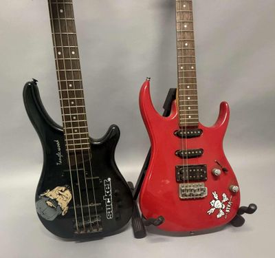 deux guitares électriques posées l'une à côté de l'autre sur une surface blanche