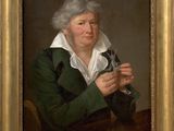portrait of a man in a green coat holding a pair of scissors