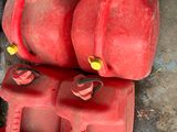 two red gas cans sitting next to each other on the ground