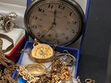 a box full of gold and silver jewelry on a table