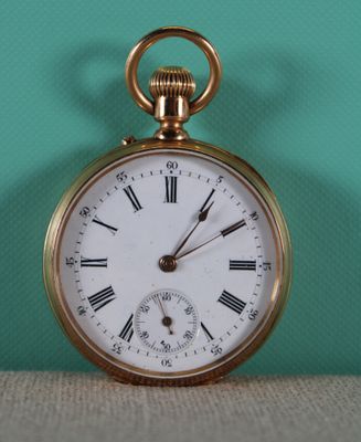 a gold pocket watch with roman numerals on the face