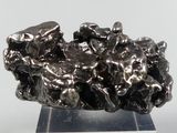 a metal sculpture of a bunch of rocks on a stand