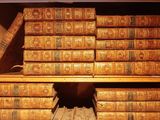 many old books stacked on a shelf in a room