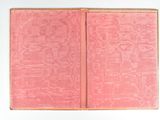 an old book with a pink cover sitting on top of a white table