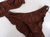 brown swimsuit on a white surface next to a pair of shoes