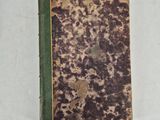 an old book sitting on top of a table next to a white wall
