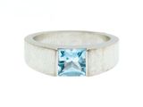 une bague en or blanc sertie d'une topaze bleue au centre