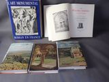 trois livres posés sur une table, sur fond noir, avec une couverture bleue