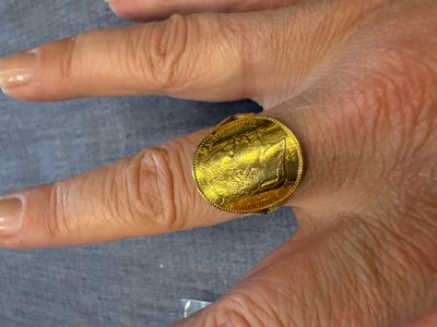 la main d'une femme à laquelle est enfilée une bague en or