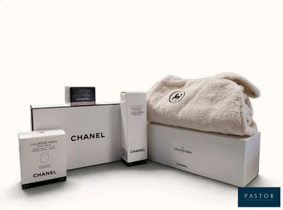 une boîte blanche sur laquelle sont posés une serviette et un flacon de parfum
