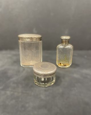 three small glass jars with lids and lids on a table