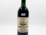 a bottle of wine sitting on top of a table next to a white background