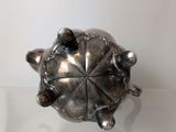 a silver turtle sitting on top of a glass table