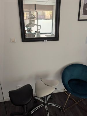 two chairs in the corner of a room with a mirror on the wall