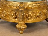 a gold clock with a glass on top of it