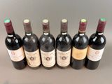 six bottles of wine are lined up in a row on a table