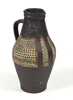 un vase noir et vert orné de motifs géométriques